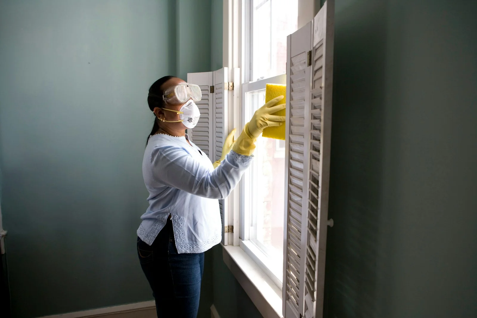 A professional cleaning an interior window